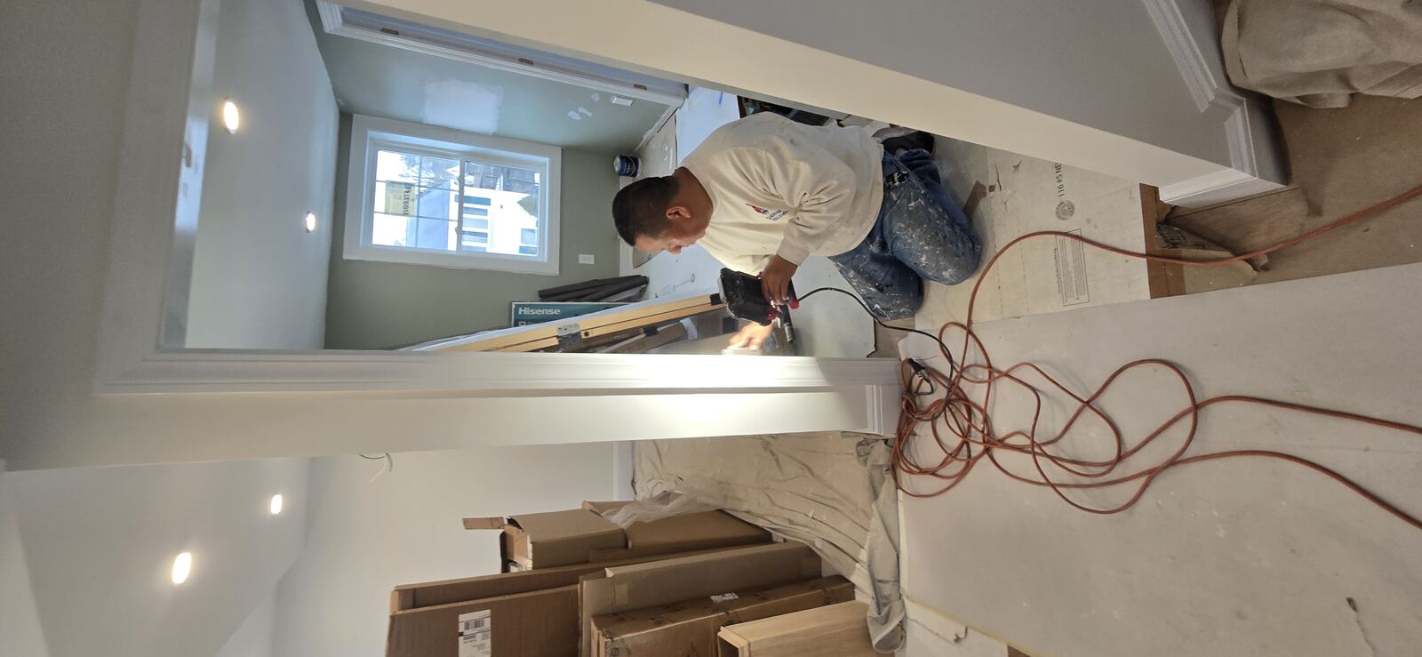 Painter on ladder finishing cedar shingle siding